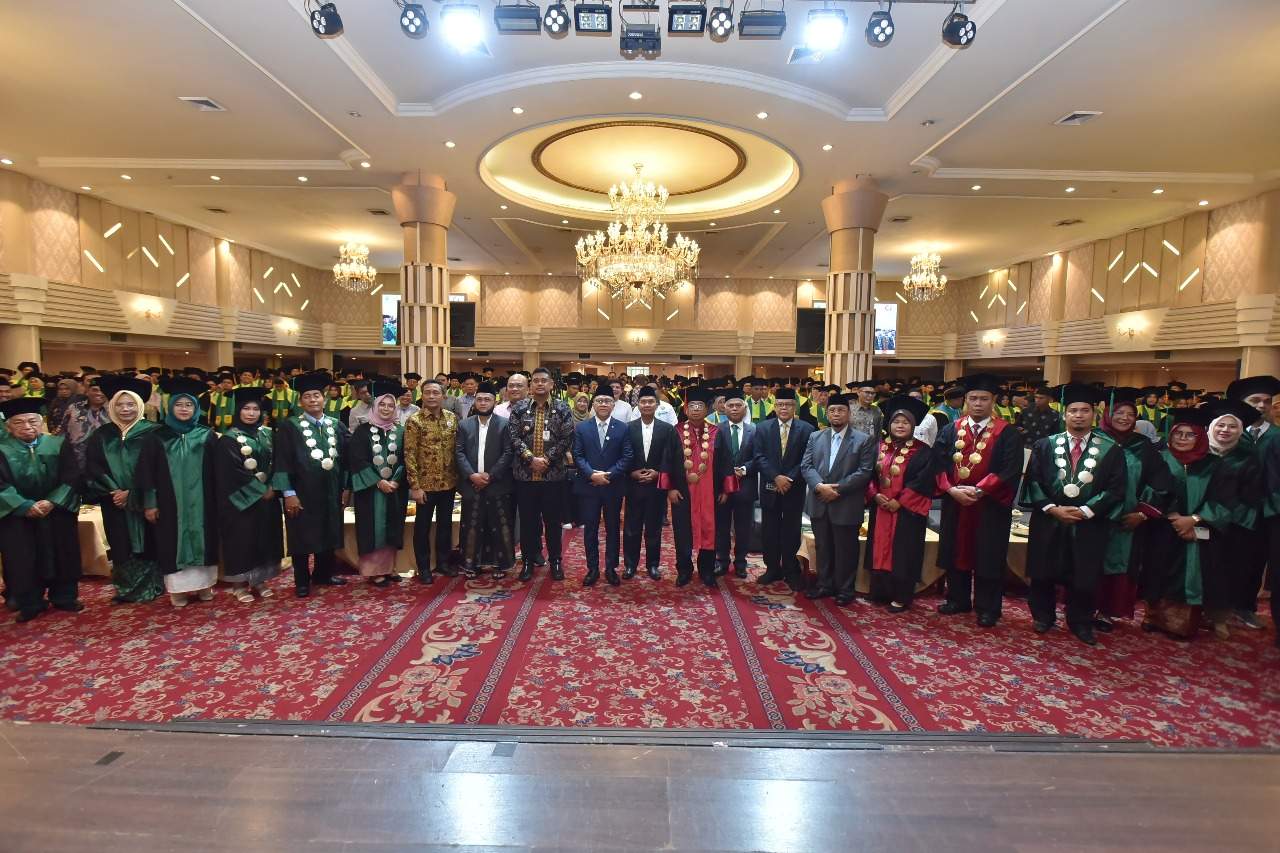 Foto suasana wisuda di panggung utama — terlihat rektor, pejabat, dan wisudawan.